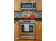 Close up of the stainless steel oven and microwave surrounded by wooden cabinets and colorful backsplash at 68 W 9Th St # B, Folly Beach, SC 29439