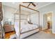 Bright main bedroom features a four-poster bed, ceiling fan, and ensuite bathroom access at 68 W 9Th St # B, Folly Beach, SC 29439