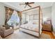 Bright main bedroom features a four-poster bed, ceiling fan, and balcony access with marina views at 68 W 9Th St # B, Folly Beach, SC 29439