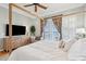 Bright main bedroom features a four-poster bed, flat screen television, and balcony access at 68 W 9Th St # B, Folly Beach, SC 29439