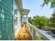 Inviting porch with wooden floorboards and white railings on a sunny day at 68 W 9Th St # B, Folly Beach, SC 29439