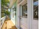 Charming porch with wooden floors, hanging lantern, and white railings next to the front door at 68 W 9Th St # B, Folly Beach, SC 29439