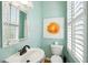 Charming powder room featuring stylish fixtures, framed art, and plantation shutters at 68 W 9Th St # B, Folly Beach, SC 29439