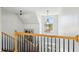 Elegant staircase with wooden railing and metal balusters, illuminated by a chandelier and natural light at 68 W 9Th St # B, Folly Beach, SC 29439