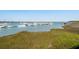 Picturesque harbor view featuring multiple boats docked in the marina with a grassy shoreline at 68 W 9Th St # B, Folly Beach, SC 29439