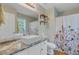 Bright bathroom featuring a sleek sink, stone countertop, and a floral shower curtain at 8363 Water Ash Way, North Charleston, SC 29420