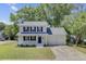 Charming two-story home featuring a covered front porch, attached two car garage, and mature trees at 8363 Water Ash Way, North Charleston, SC 29420