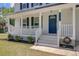 Inviting front porch with white railings, steps, and a blue front door at 8363 at 8363 Water Ash Way, North Charleston, SC 29420