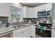 Kitchen featuring stainless steel appliances, white cabinets, tile backsplash, and granite countertops at 8363 Water Ash Way, North Charleston, SC 29420
