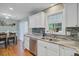 Bright kitchen with stainless steel appliances, white cabinets, tile backsplash, and a view into the dining area at 8363 Water Ash Way, North Charleston, SC 29420