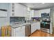 Bright kitchen features stainless steel appliances, granite countertops, and white cabinets at 8363 Water Ash Way, North Charleston, SC 29420
