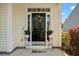 Welcoming front entrance featuring a black door with a wreath and potted plants at 8956 N Red Maple Cir, Summerville, SC 29485