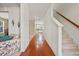 Bright hallway with hardwood floors leading to the carpeted stairs and living area at 8956 N Red Maple Cir, Summerville, SC 29485