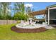 Beautiful backyard with a stone patio, pergola, and comfortable seating around a fire pit at 9781 Roseberry St, Ladson, SC 29456