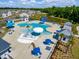 Aerial view of the modern community pool with slides, umbrellas, and lounge chairs by the water at 9781 Roseberry St, Ladson, SC 29456