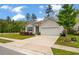 Well-maintained home with a spacious driveway, landscaped yard, and attached garage at 9781 Roseberry St, Ladson, SC 29456
