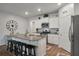 An open concept kitchen with granite counters, stainless appliances, and white cabinets provides ample seating at the island at 9781 Roseberry St, Ladson, SC 29456