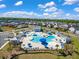 Community pool featuring unique design, lounge chairs, umbrellas, and a recreation building with neighborhood homes in the background at 9781 Roseberry St, Ladson, SC 29456