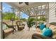 Cozy screened porch featuring wicker furniture, ambient lighting, and views of the backyard at 9781 Roseberry St, Ladson, SC 29456