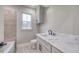 Bathroom featuring a tile accent wall, marble countertop, window, and light gray vanity at 00 Woodland Dr, Summerville, SC 29485