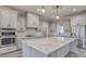 Elegant kitchen features a large island, white cabinets, stainless appliances and decorative pendant lighting at 00 Woodland Dr, Summerville, SC 29485