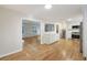 Open-concept kitchen and dining area featuring stainless steel appliances, hardwood floors, and white cabinets at 104 Huntington Cir, Summerville, SC 29485