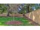 Spacious, fenced-in backyard with mature trees, a manicured lawn, and a freshly installed wooden fence at 1049 Bradford Ave, Charleston, SC 29412