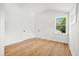 Bright bedroom with hardwood floors, white trim, and a window overlooking lush greenery at 1049 Bradford Ave, Charleston, SC 29412
