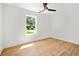 Bright bedroom with hardwood floors, a modern ceiling fan, and a large window with a neighborhood view at 1049 Bradford Ave, Charleston, SC 29412