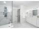 Bright white bathroom featuring double vanity, marble counters and floors, with glass-enclosed shower and ample lighting at 105 Kirkhaven Ct, Goose Creek, SC 29445