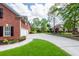 Long driveway leading to a brick home with a two-car garage, lush landscaping, and mature trees at 105 Kirkhaven Ct, Goose Creek, SC 29445