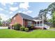 Well-maintained brick house with a screened porch, landscaped yard, and a partial view of the backyard at 105 Kirkhaven Ct, Goose Creek, SC 29445