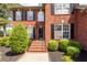 Inviting brick front entrance with landscaped bushes, black shutters, and stairs at 105 Kirkhaven Ct, Goose Creek, SC 29445