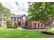 Charming two-story brick home with a manicured lawn, mature trees, and a welcoming front entrance at 105 Kirkhaven Ct, Goose Creek, SC 29445