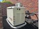 Generac home generator for backup power, installed outside on stone with brick surround and mulch at 105 Kirkhaven Ct, Goose Creek, SC 29445