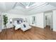 Bright bedroom with tray ceiling, hardwood floors, and view to ensuite bath at 105 Kirkhaven Ct, Goose Creek, SC 29445