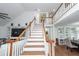 Staircase leading to an upper level featuring hardwood steps, white risers, and banister with view of dining area at 105 Kirkhaven Ct, Goose Creek, SC 29445