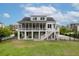 Expansive backyard view with outdoor patio, a large screened porch, a staircase to the fenced yard, and lush landscaping at 1104 Beresford Run, Charleston, SC 29492