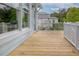 Exterior shot of a wooden deck, light blue siding, and a white railing overlooking a green landscape at 1104 Beresford Run, Charleston, SC 29492