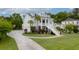 Charming light-blue two-story home with a welcoming staircase and columns, a long driveway, and lush landscaping at 1104 Beresford Run, Charleston, SC 29492