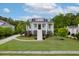 Charming light-blue two-story home with a welcoming staircase, columns, a well-manicured lawn, and lush landscaping at 1104 Beresford Run, Charleston, SC 29492