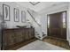 Elegant foyer featuring a wooden console table, staircase, and a dark wood entry door at 1104 Beresford Run, Charleston, SC 29492