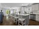 Bright kitchen features stainless appliances, white cabinets and island with bar seating adjacent to living room at 1104 Beresford Run, Charleston, SC 29492