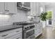 Gourmet kitchen featuring a stainless steel range, custom cabinetry, and bright backsplash at 1104 Beresford Run, Charleston, SC 29492