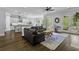 Open living space with hardwood floors, dark sofa, access to kitchen, fireplace and outdoor space at 1104 Beresford Run, Charleston, SC 29492