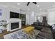 Comfortable living room with fireplace, dark sofas, ceiling fan, and hardwood floors at 1104 Beresford Run, Charleston, SC 29492