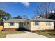 Charming ranch-style home featuring a well-manicured lawn, light yellow siding, and inviting blue shutters at 1120 Seaside Ln, Charleston, SC 29412