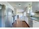 Well-lit kitchen boasts stainless steel appliances, granite countertops, white cabinets, and dark wood floors at 118 Willowbend Ln, Summerville, SC 29485