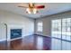 Cozy living room featuring a classic fireplace, modern ceiling fan, and dark wood floors, creating a warm ambiance at 118 Willowbend Ln, Summerville, SC 29485
