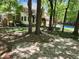 This backyard showcases a stone path leading to a pool and the home's rear exterior amidst lush trees at 130 Delaney Cir, Summerville, SC 29485
